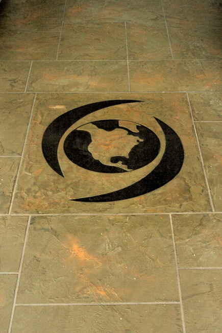 Custom globe logo inlay in StoneCraft flooring